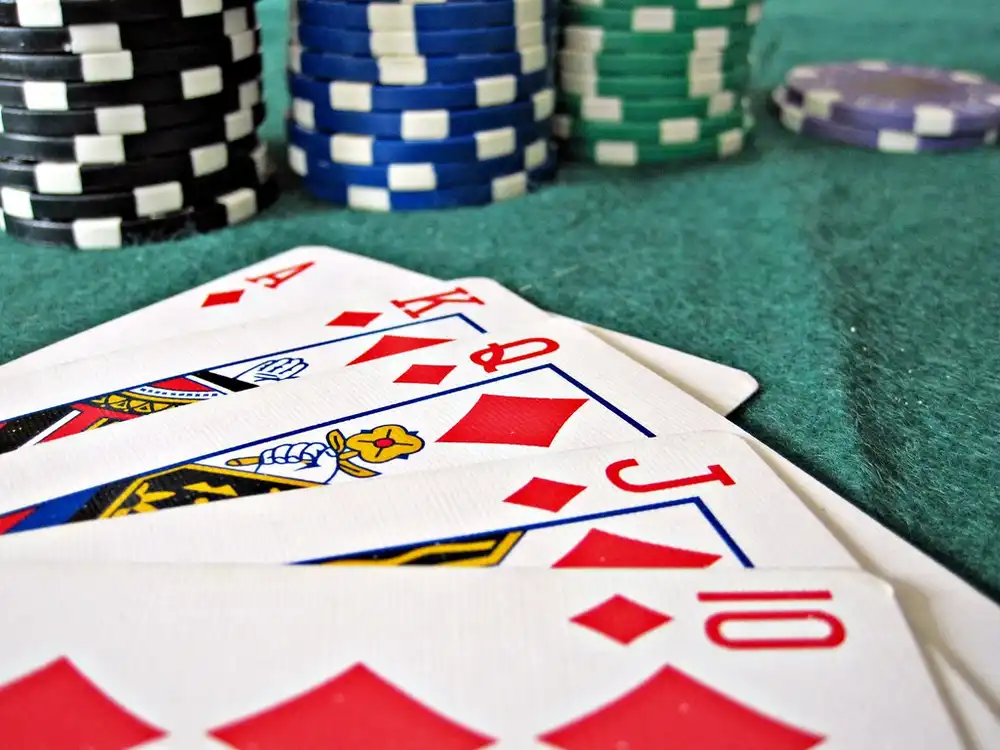 Cartas e fichas sobre o pano verde de uma mesa de jogo