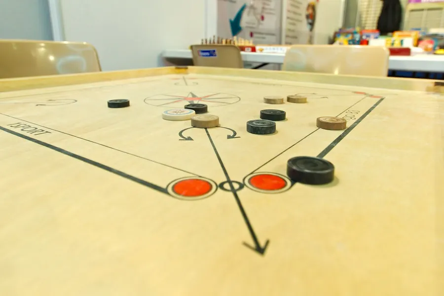 Tabuleiro de carrom visto de cima com os discos posicionados