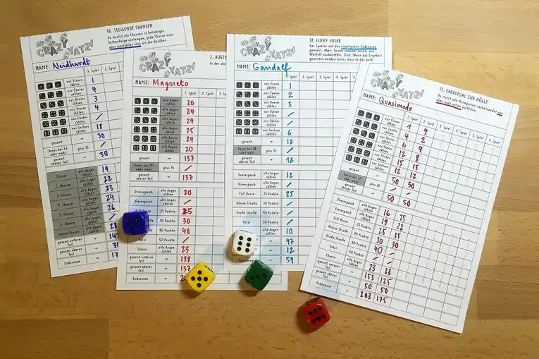 Dados e folhas de pontuação sobre uma mesa de madeira